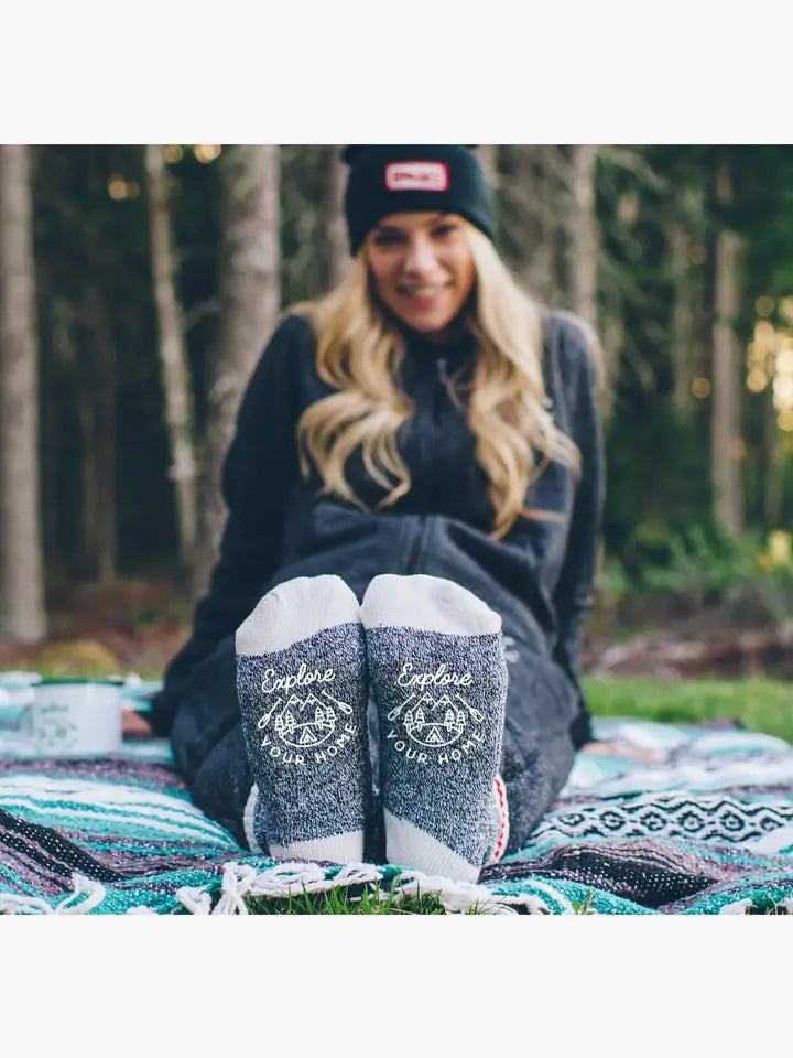 person sitting on a blanket outside with feet stretched out front showing bottoms