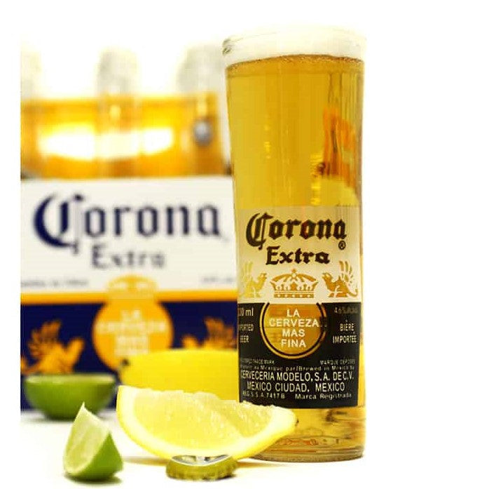 tall glass filled to the top with lemon & lime wedge and bottle cap beside it