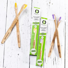 Load image into Gallery viewer, Showing the yellow and the purple laser engraved tooth brushes with 2 tooth brush boxes in between

