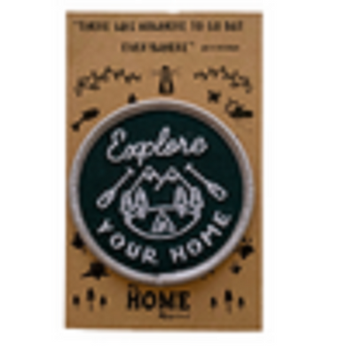 patch with green and white stitching on cardboard backing 