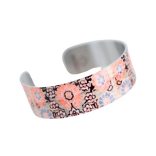 Load image into Gallery viewer, peachy orange flowers and blue flowers smaller white flowers printed on a silver bracelet
