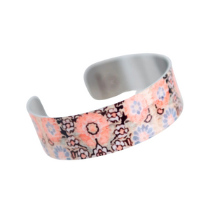 peachy orange flowers and blue flowers smaller white flowers printed on a silver bracelet