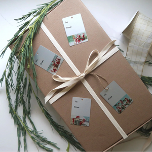 gift wrapped in brown paper with bow and four gift tags on top