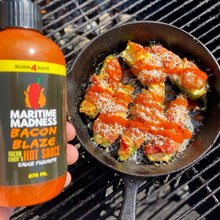 Load image into Gallery viewer, a close up of a bottle labelled Maritime Madness in white over a BBQ with a pan of jalapenos 
