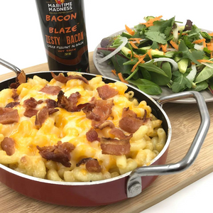 a plate of mac' n cheese with a bottle beside labelled in brown Bacon Blaze