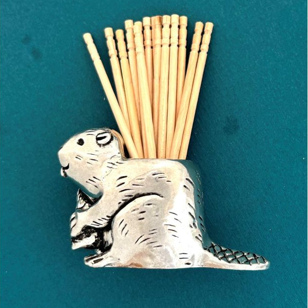 silver beaver tooth pick holder against a blue background