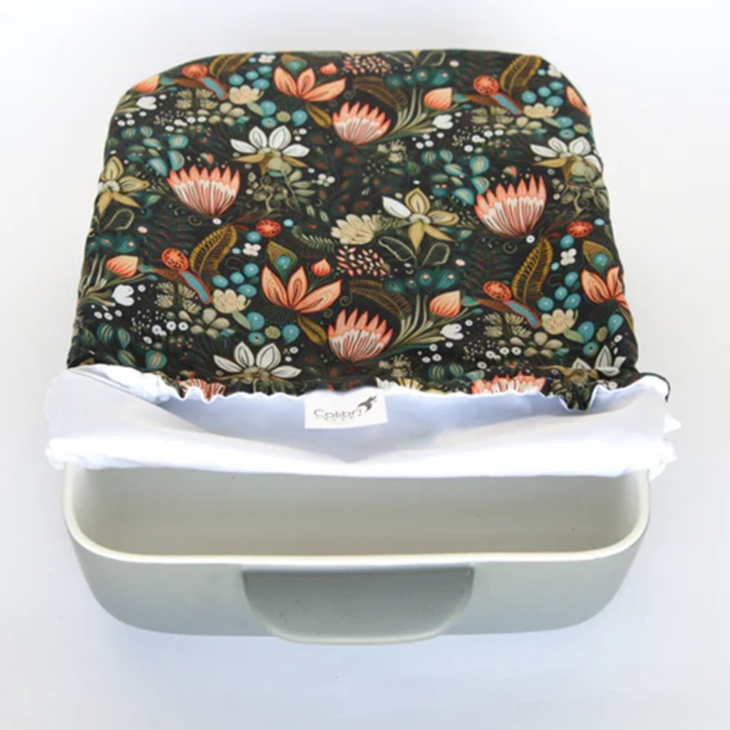 Floral-patterned cover on a white casserole container with a visible brand label.