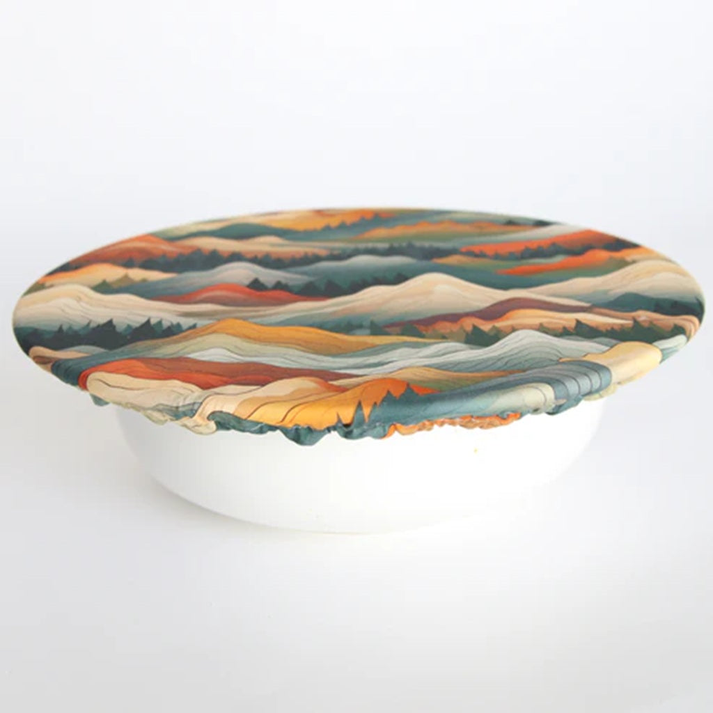 Colorful mountain-patterned bowl cover on a white background