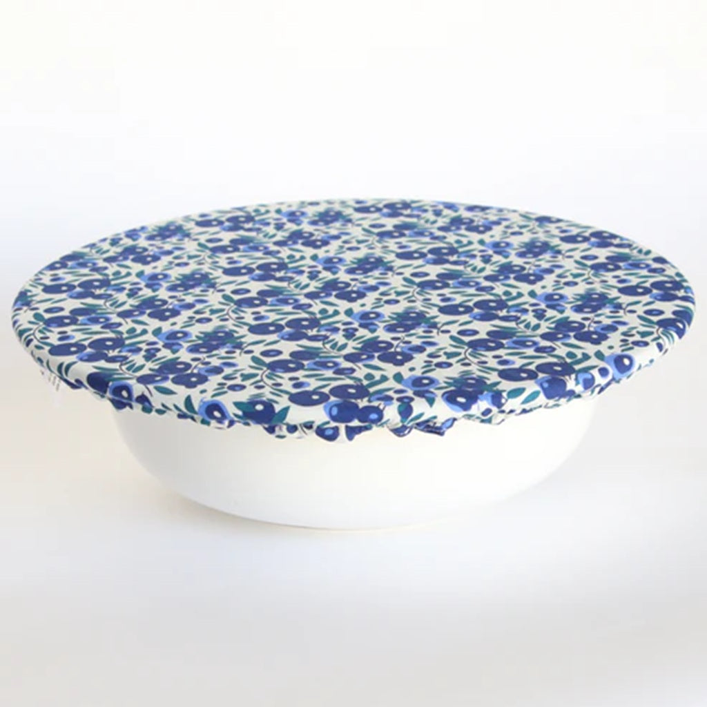 White bowl with a blue floral pattern bowl cover on a white background