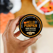 Load image into Gallery viewer, hand holding a round top of the jar with black label -orange print and picture of a pumpkin
