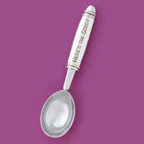 A silver spoon with a white handle engraved with the text 'Here's the Spoon', presented diagonally on a solid purple square background.