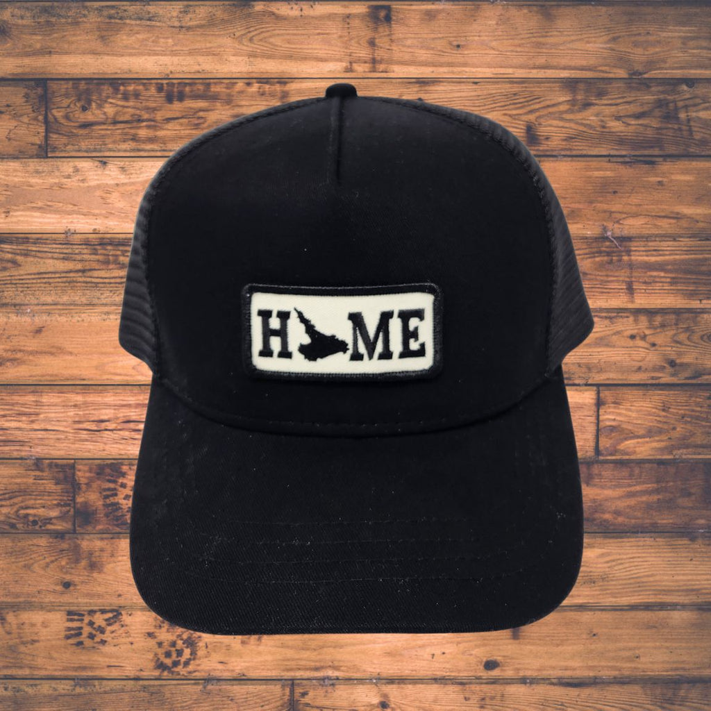 Black cap with Labrador 'HOME' patch on a wooden surface
