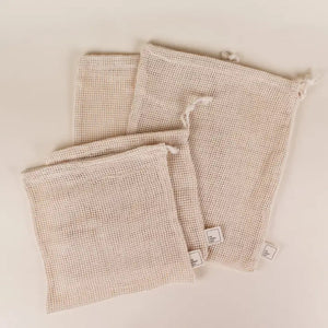 two different sizes of four cotton mesh produce bags laying on side