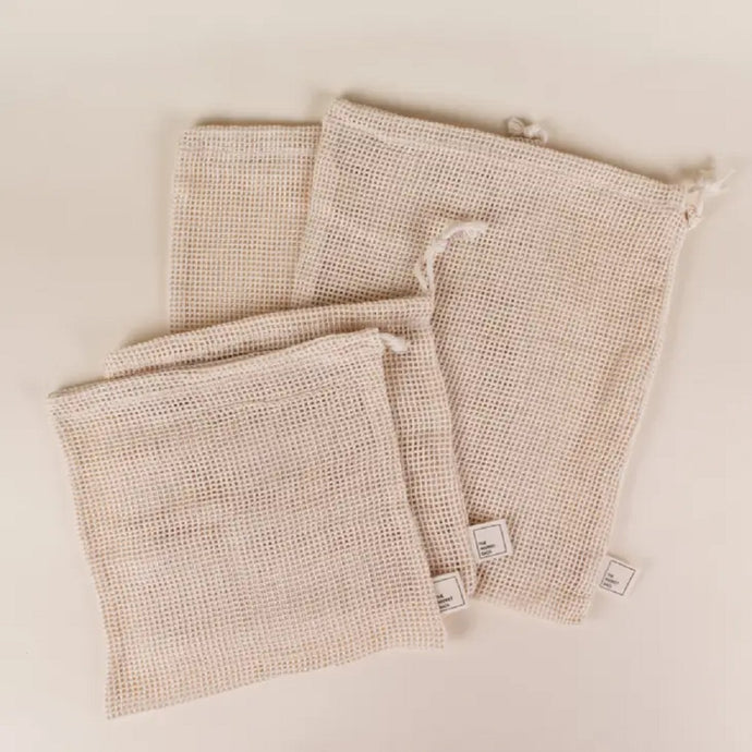 two different sizes of four cotton mesh produce bags laying on side