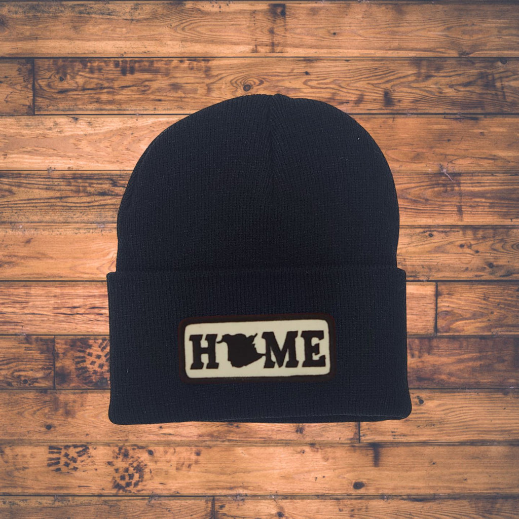 Black beanie with New Brunswick 'HOME' patch on a wooden surface