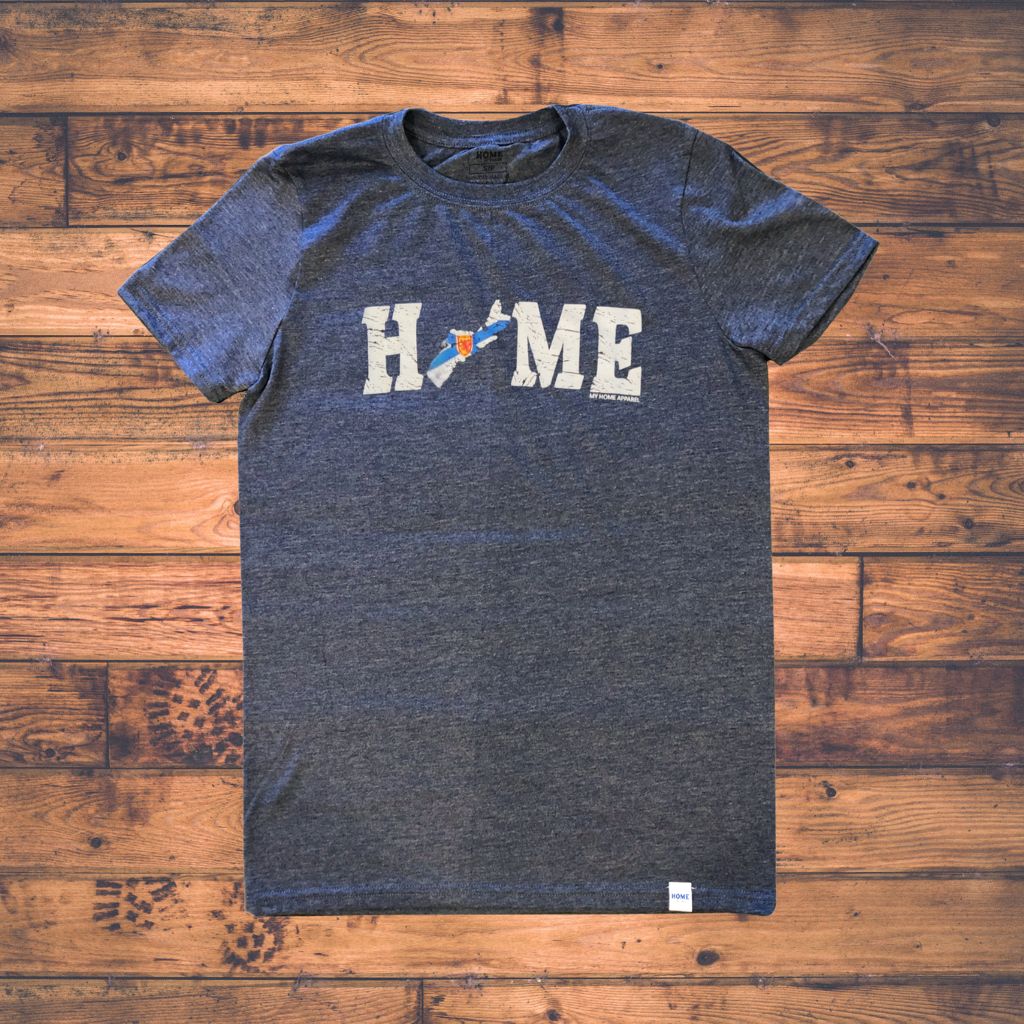 Blue t-shirt with Nova Scotia 'HOME' graphic on a wooden surface