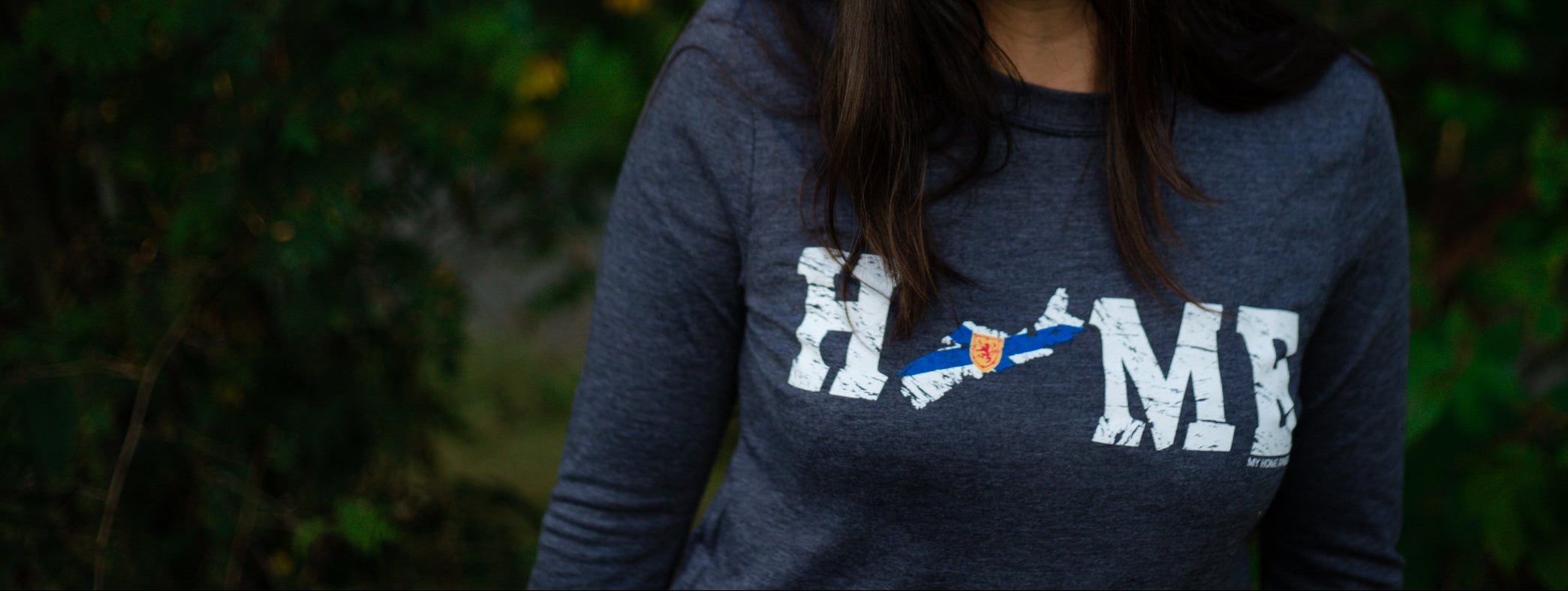 Person wearing a My Home Apparel HOME t-shirt the the Nova Scotia flag as the O