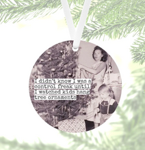 Load image into Gallery viewer, black and white photo, 1950&#39;s, woman hanging decorations on a tree and small child
