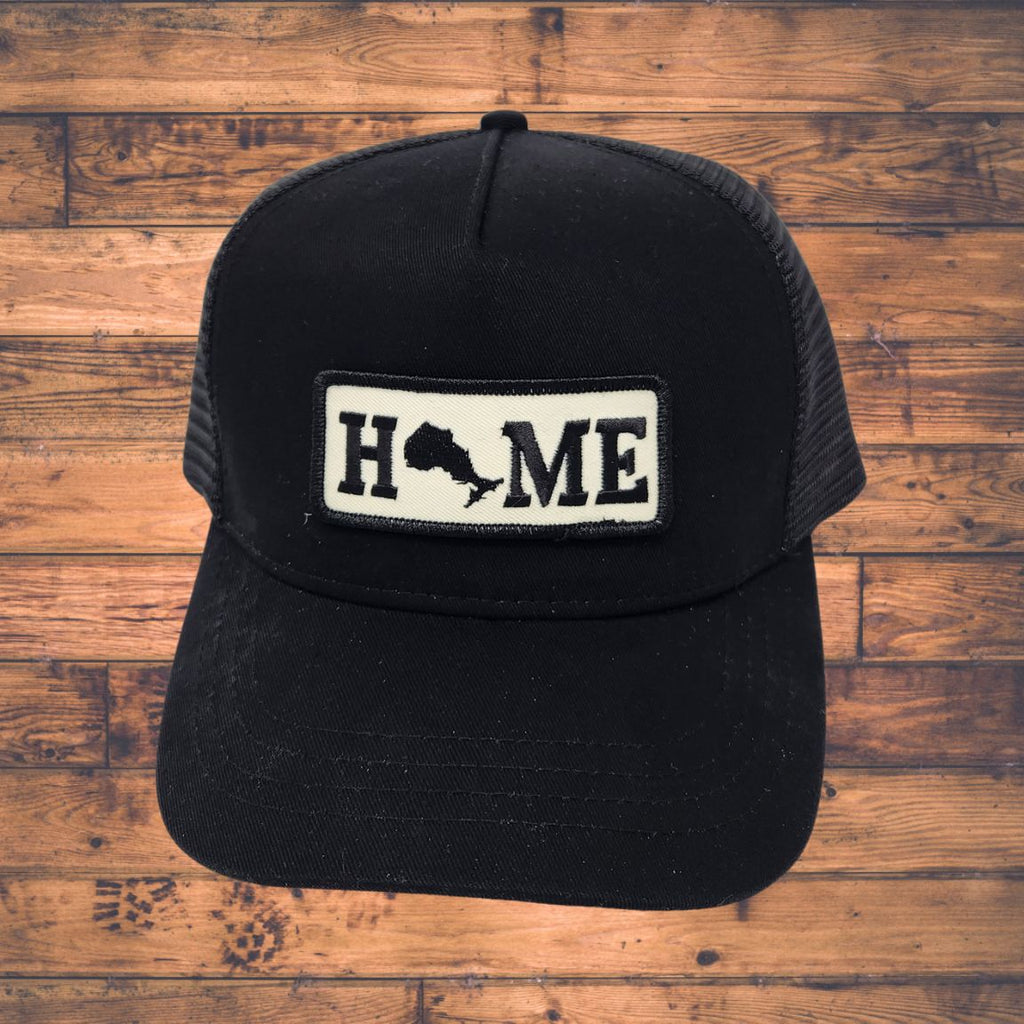Black cap with Ontario 'HOME' patch on a wooden surface
