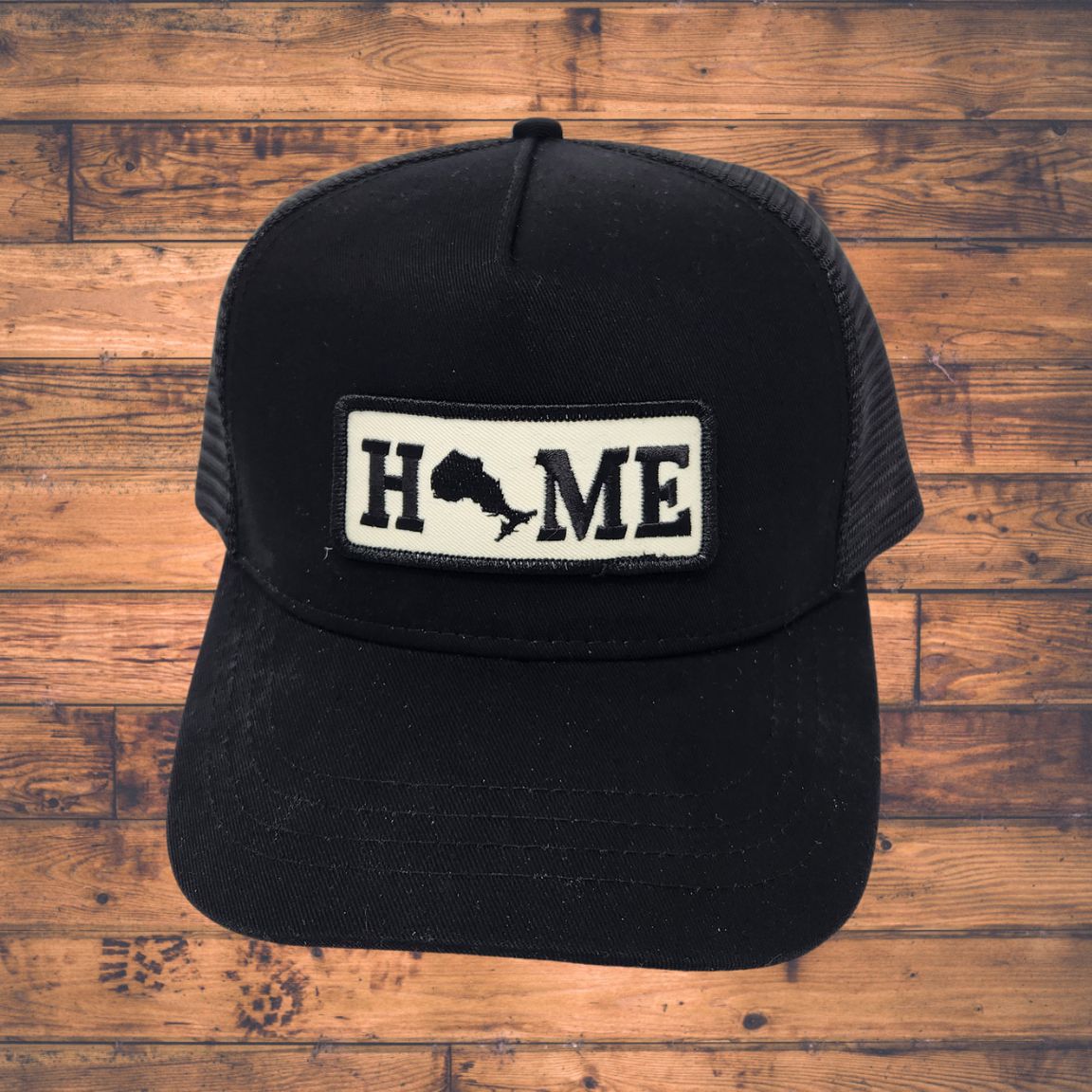 Black cap with Ontario 'HOME' patch on a wooden surface