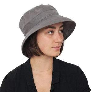 woman with a black blouse wearing a grey linen Bowler ha