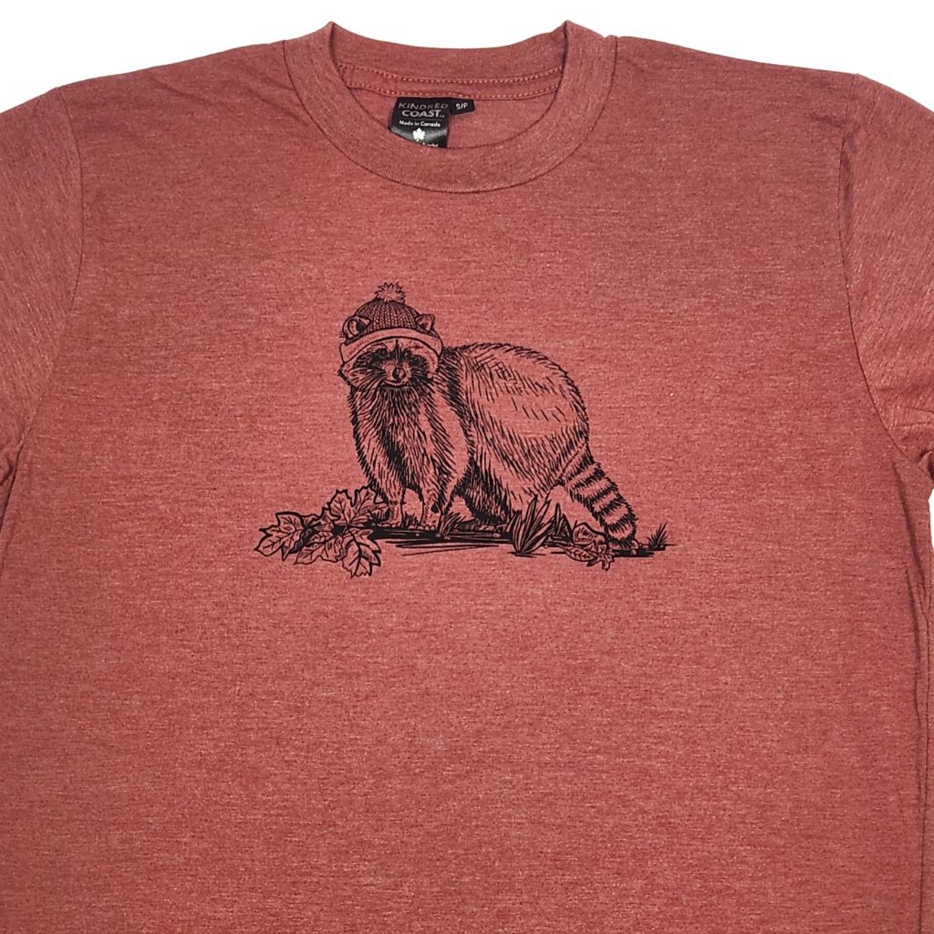 close up of a red t shirt with a black print of a  raccoon wearing a hat