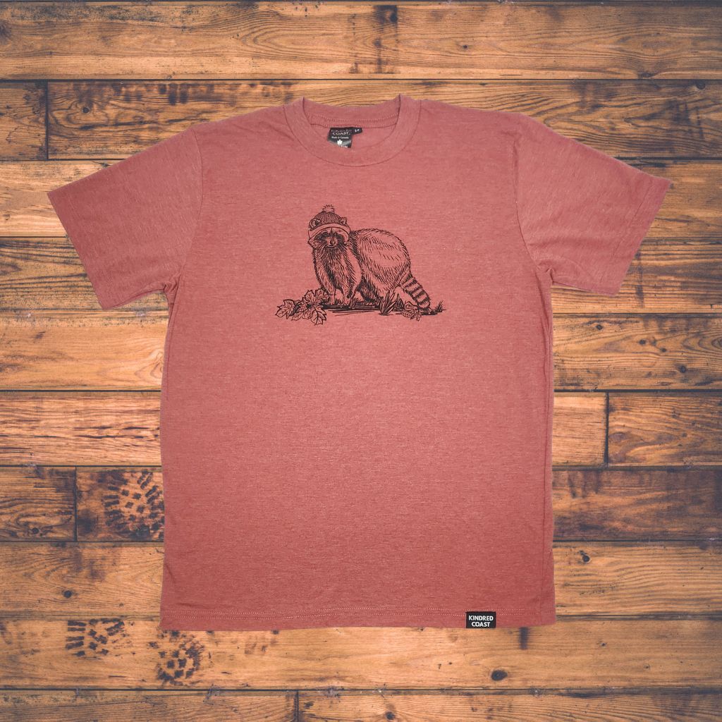 red shirt with print of raccoon on wood  floor background