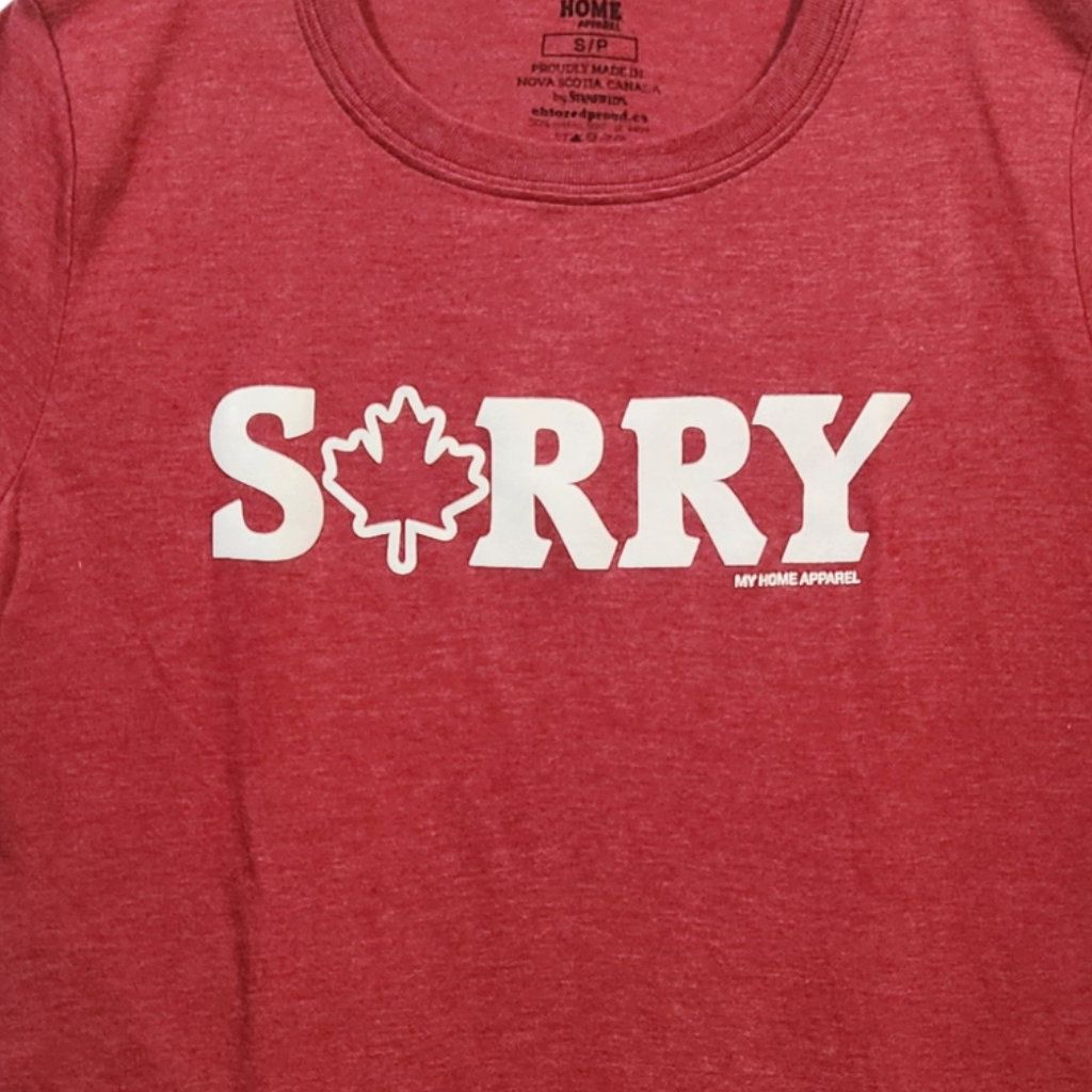 Red t-shirt with 'SORRY' and a maple leaf graphic on a plain background