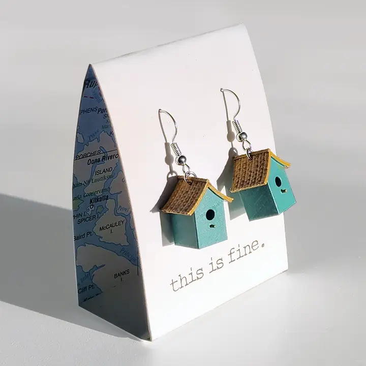 Birdhouse-shaped earrings on a card with 'this is fine' text