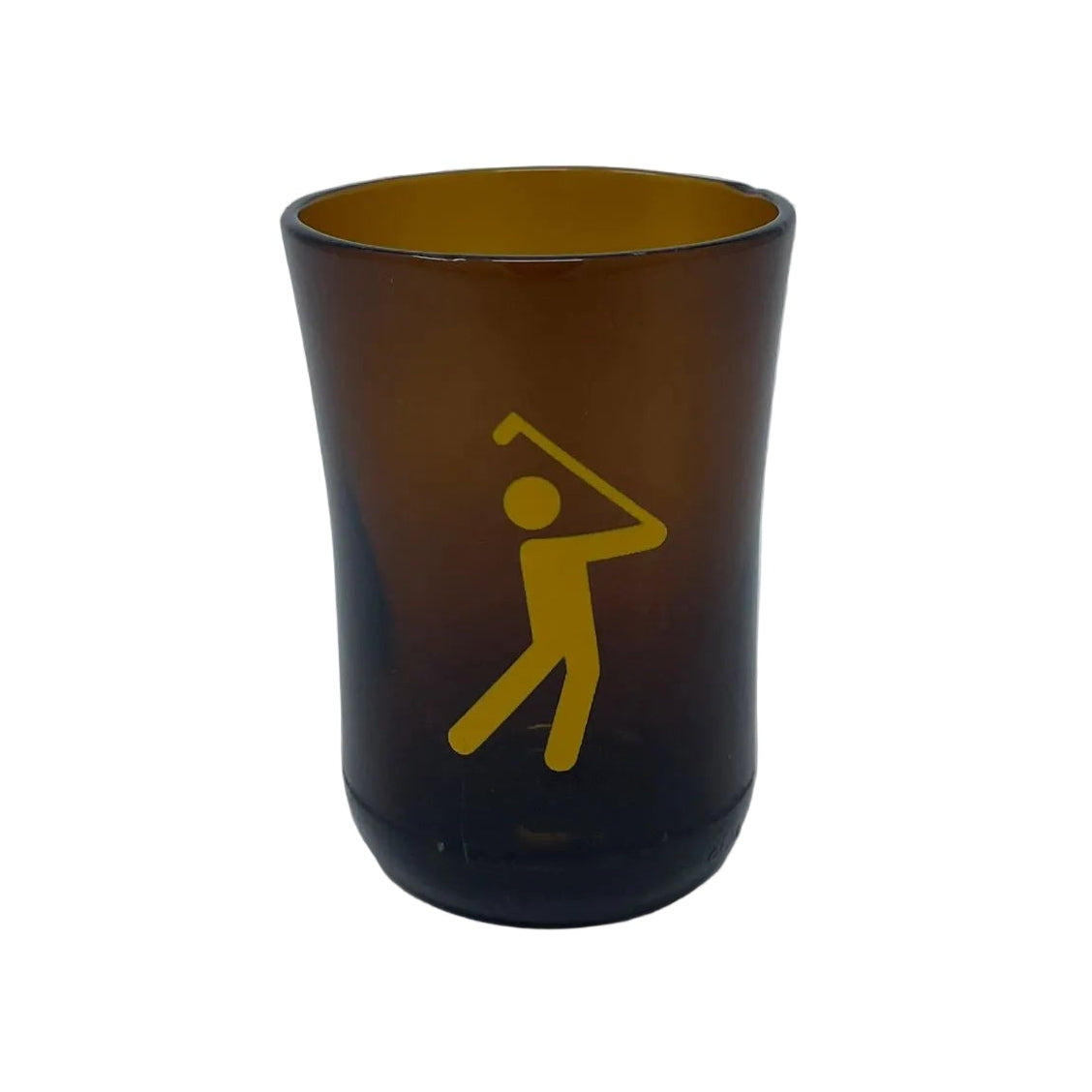 An amber brown translucent shot glass featuring a yellow graphic of a golfer, set against a plain light gray background.