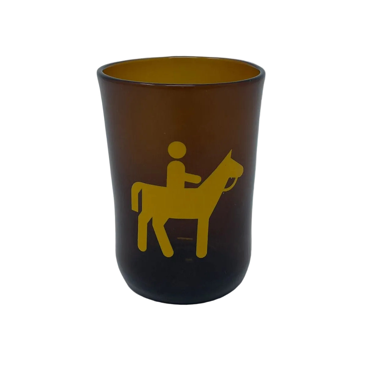 An amber brown translucent glass tumbler with a yellow graphic of a rider on a horse, set against a plain light gray background.