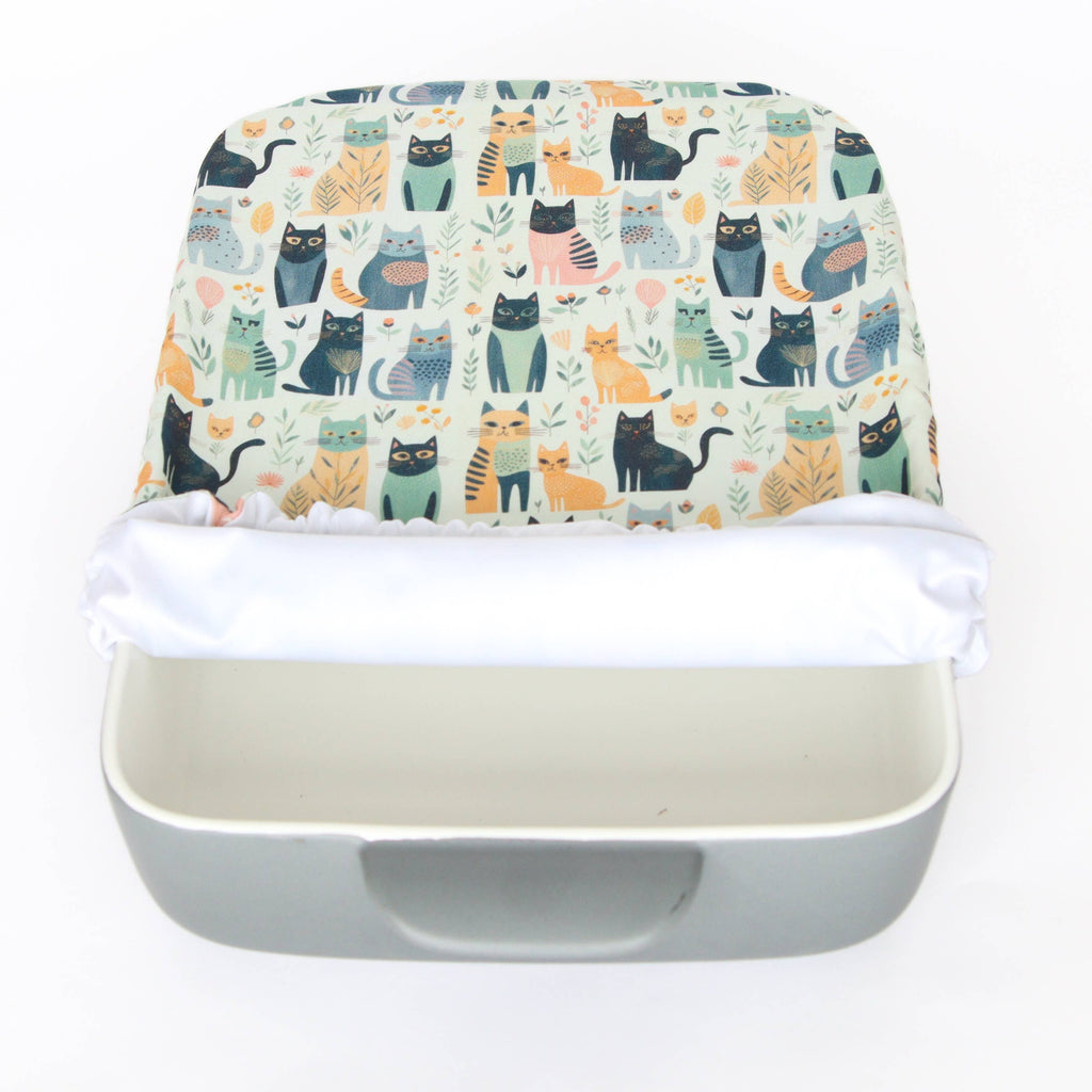 light coloured casserole cover with cat prints 3/4 of the way on a dish