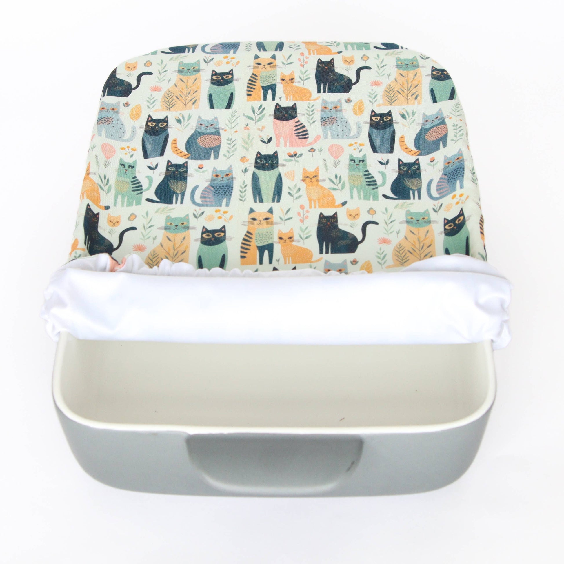light coloured casserole cover with cat prints 3/4 of the way on a dish