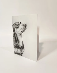 Dachshund on the front of a card looking up