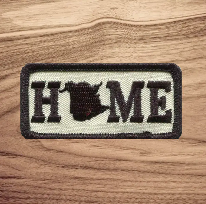  New Brunswick HOME Patch with black stitching and outline on a wood background