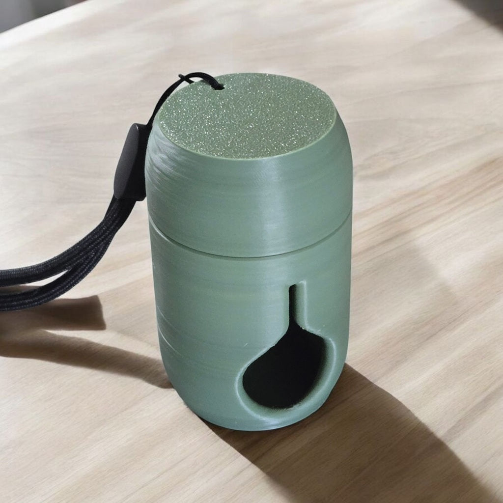 green poop bag holder sitting on a counter empty