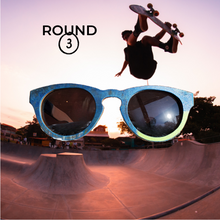 Load image into Gallery viewer, front view of wooden sunglasses with skateboard park and skateboarder in the background
