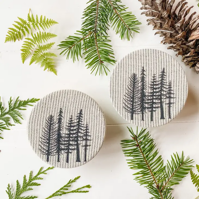two jar covers with five pine trees printed on each