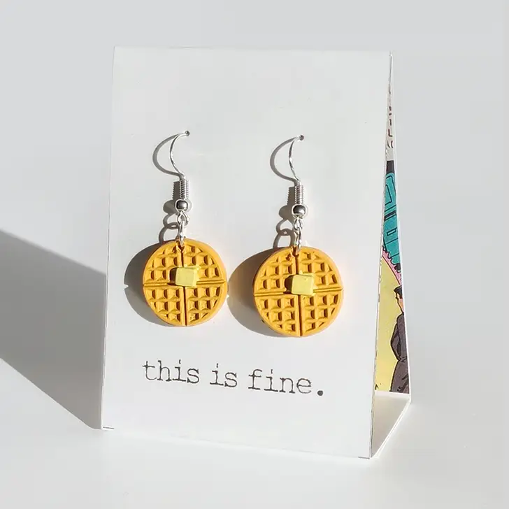 Yellow waffle-shaped earrings on a card with 'this is fine.' text, against a white background.