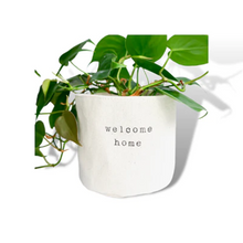 Load image into Gallery viewer, side view of a green plant inside a cloth pot cover that has dark printing on it
