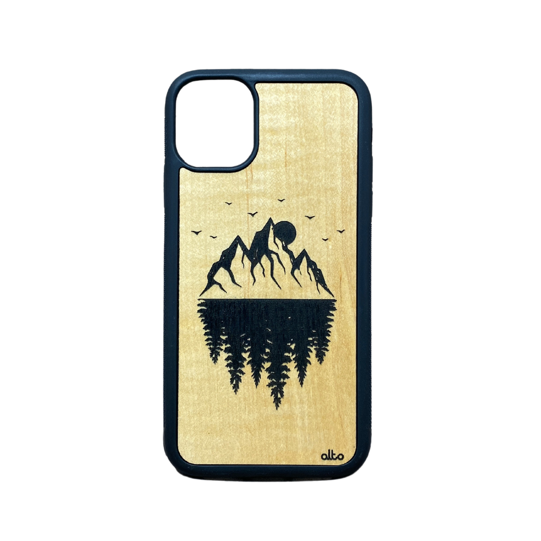 mountains but their reflection is mimicked by pine trees - a sun and birds flying 