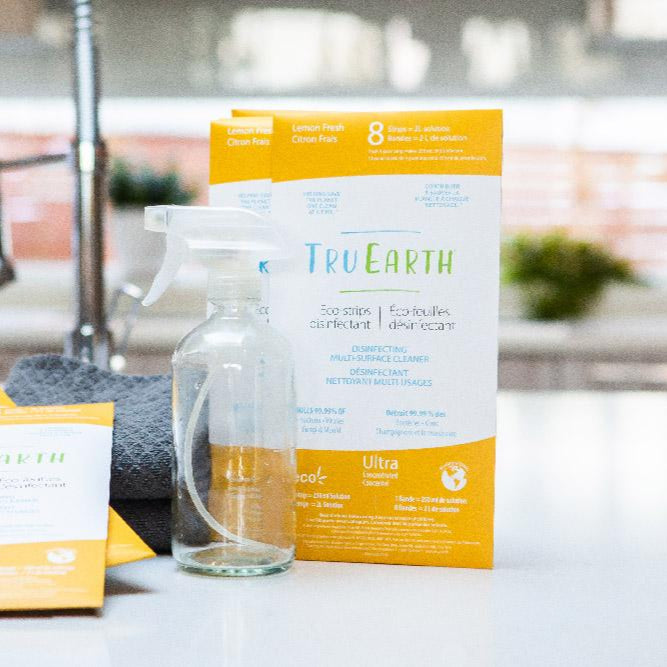 packages of Tru Earth cleaner sitting on a kitchen counter. The packaging is white and yellow