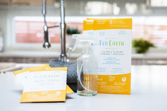packages of Tru Earth cleaner sitting on a kitchen counter. The packaging is white and yellow