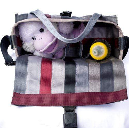 top view of bag open showing a stuff monkey and bottle inside with extra space